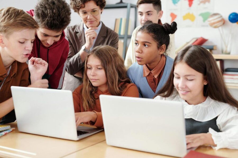 Diverse middle school students collaboratively working on laptops in classroom, demonstrating inclusive digital learning and accessible education technology